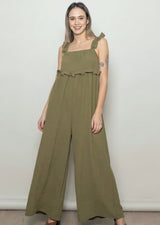 woman wearing an olive green ruffled jumpsuit with wide legs and adjustable straps
