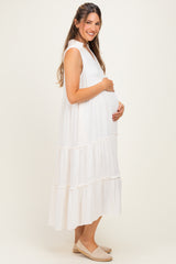 woman wearing a white tiered maternity dress and holding her baby bump