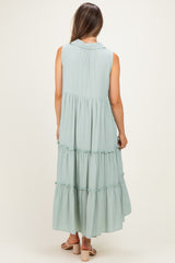 woman wearing a sleeveless light green maternity maxi dress with tiered ruffles, showing the back view