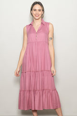 woman wearing a pink sleeveless maxi dress with a collared neckline and tiered ruffle details