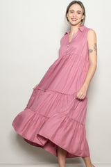 woman wearing a pink sleeveless tiered dress with a collar and button details