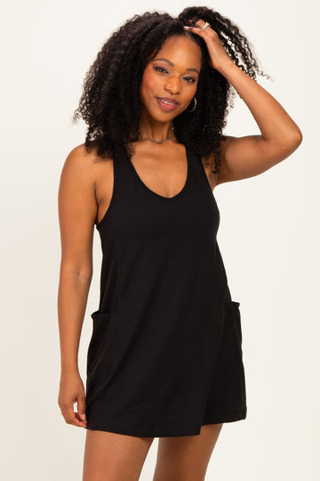 woman wearing a black sleeveless romper with side pockets and a relaxed fit