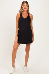 woman wearing a black maternity tank dress with side pockets and a visible baby bump