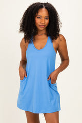woman wearing a light blue sleeveless dress with pockets and a relaxed fit