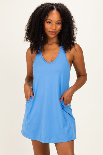 woman wearing a light blue sleeveless dress with pockets and a relaxed fit