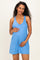 woman wearing a light blue maternity romper and holding her baby bump