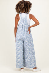 woman wearing a blue floral print maternity jumpsuit with wide legs, styled with a white top underneath