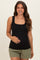 woman wearing a black square neck maternity tank top and holding her baby bump with olive green shorts