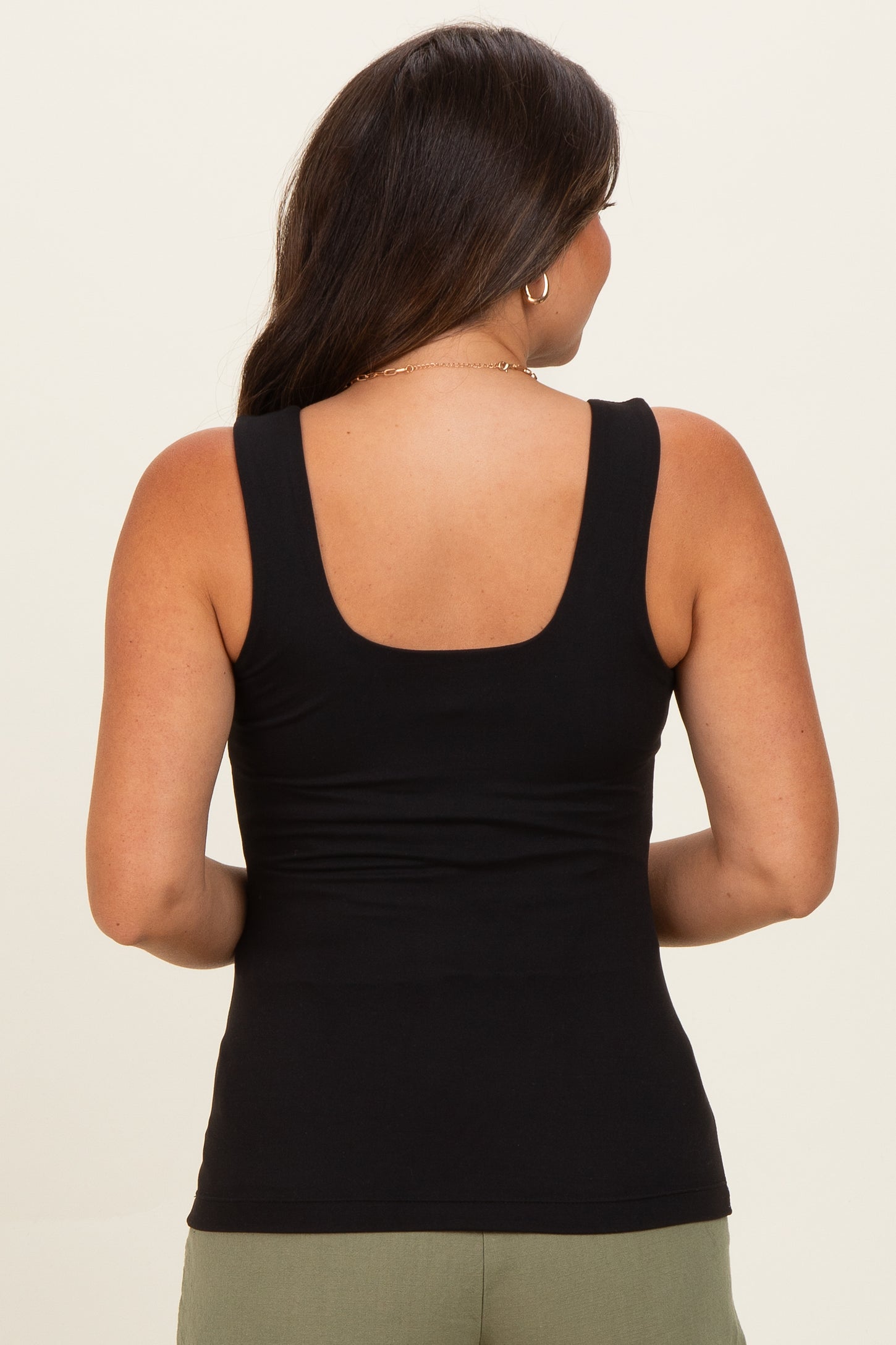 woman wearing a black maternity tank top, seen from the back