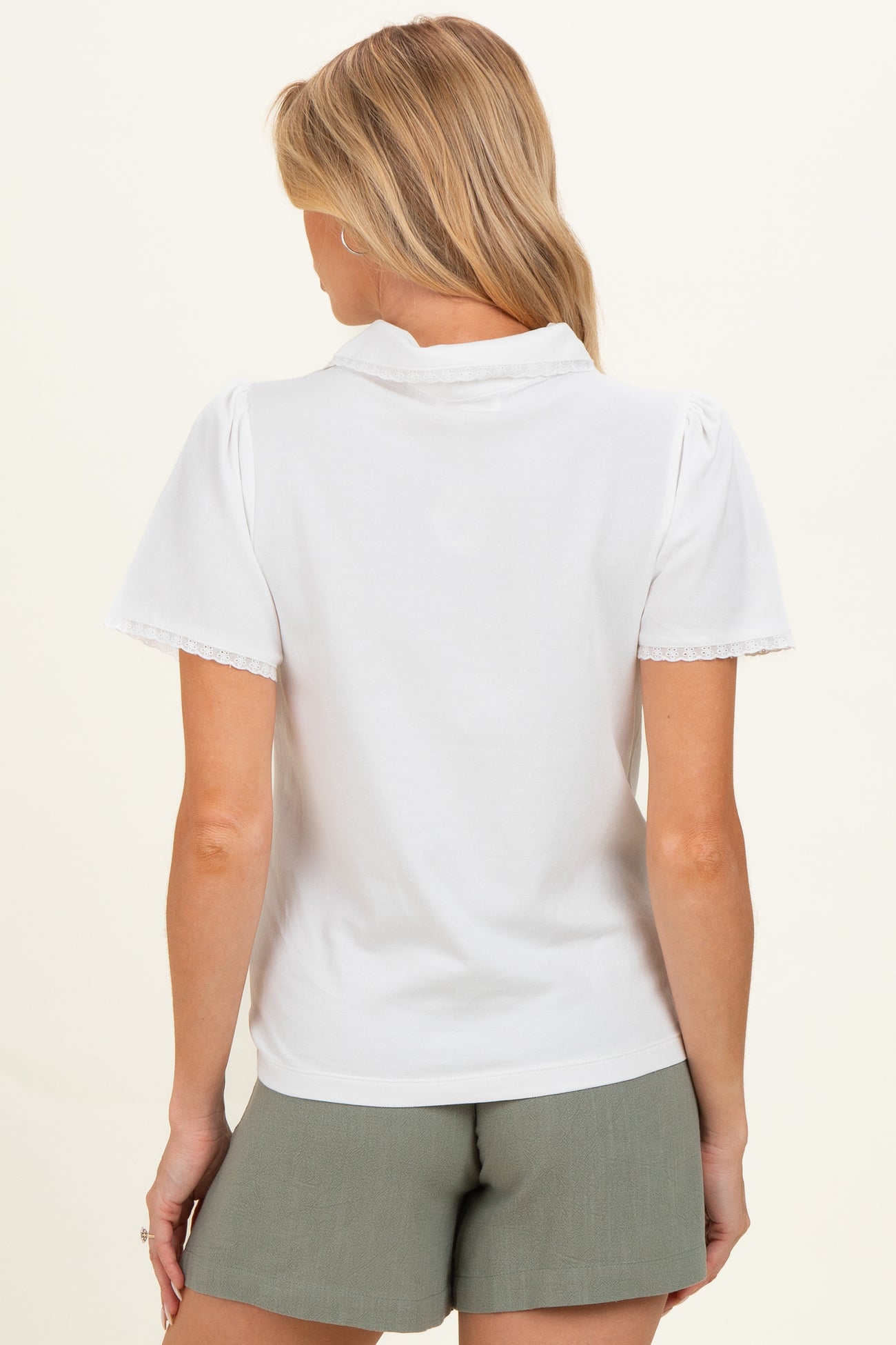 woman wearing a white short sleeve maternity top with lace trim and back view showing the collar detail