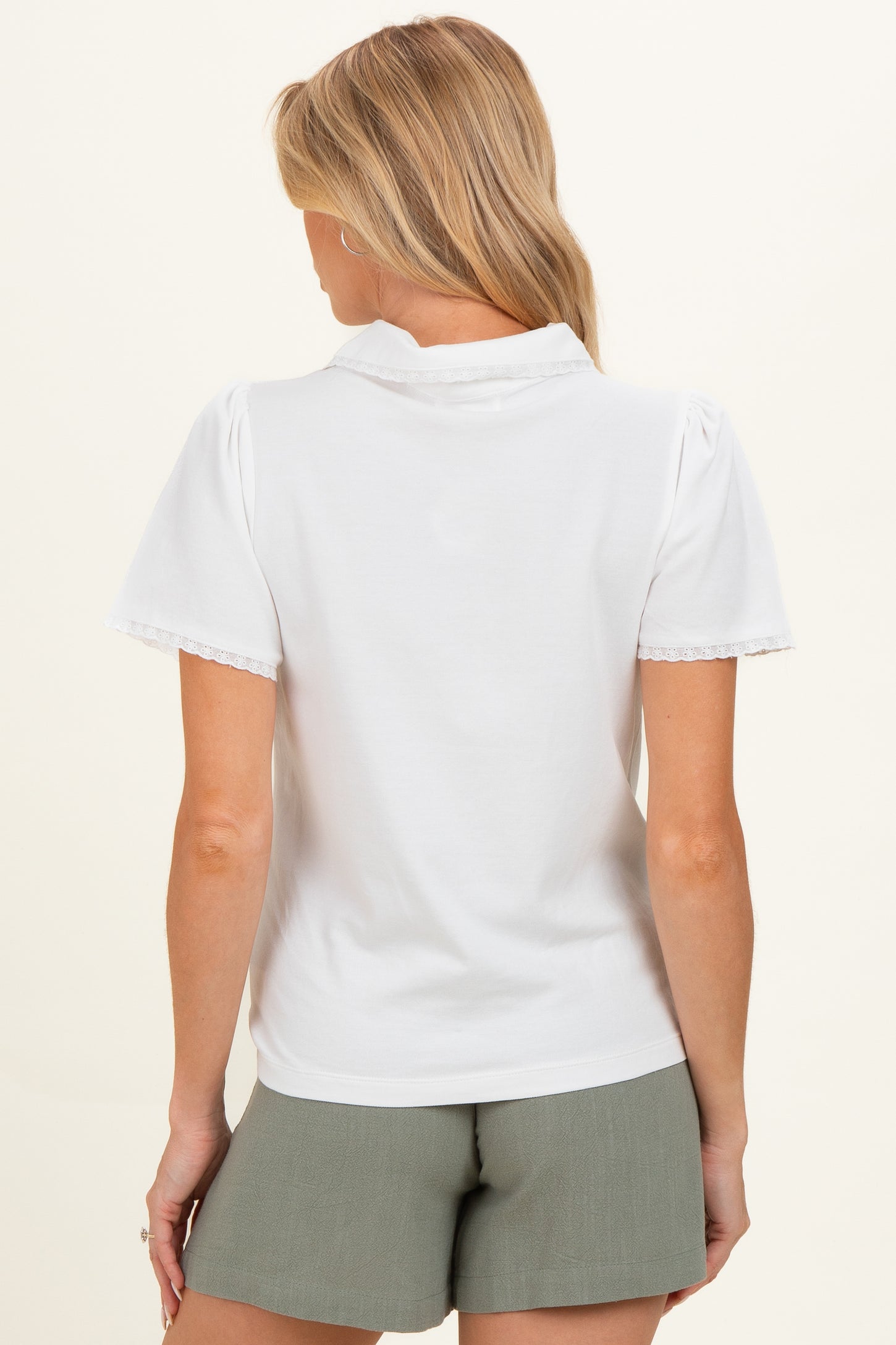 woman wearing a white short sleeve maternity top with lace trim and back view showing the collar detail