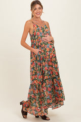 woman wearing a floral print maxi maternity dress with pockets and a visible baby bump