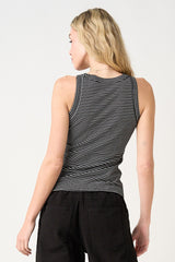 woman wearing a black and white striped sleeveless top, showing the back view with a fitted silhouette