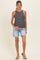 woman wearing a black and white striped maternity tank top and light blue distressed shorts, holding her baby bump