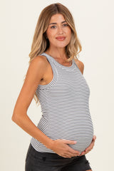 woman wearing a black and white striped maternity tank top and holding her baby bump