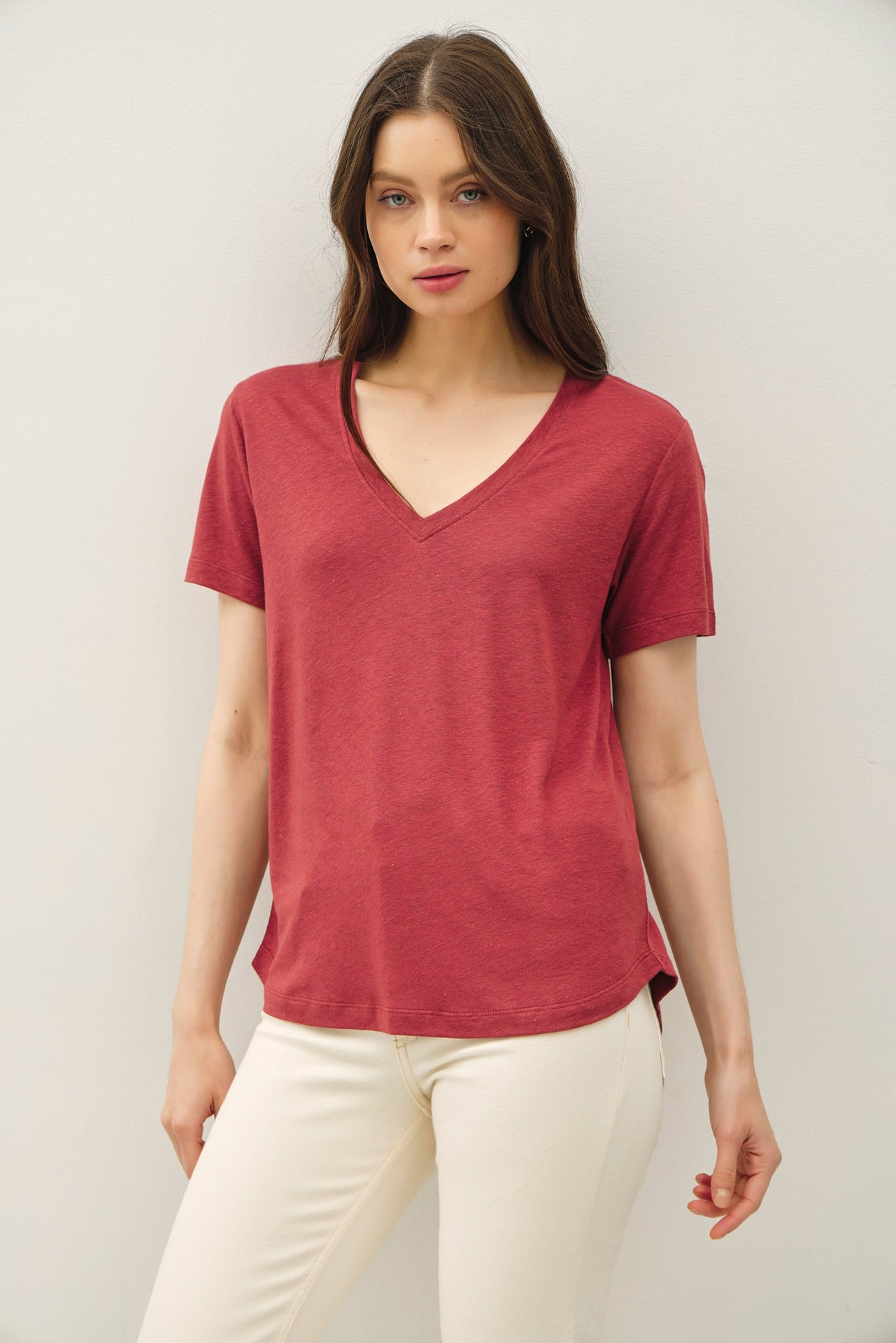 woman wearing a burgundy v-neck t-shirt with short sleeves and a relaxed fit