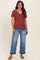 woman wearing a maroon v-neck maternity top with short sleeves and light blue wide-leg maternity jeans