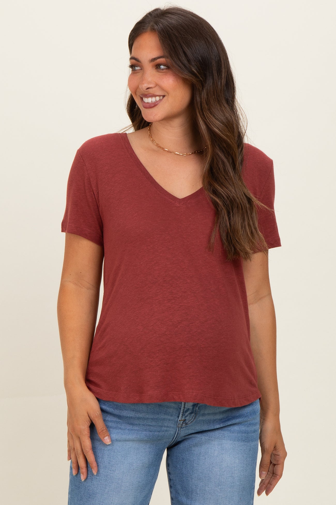 woman wearing a rust v-neck maternity t-shirt with short sleeves and relaxed fit