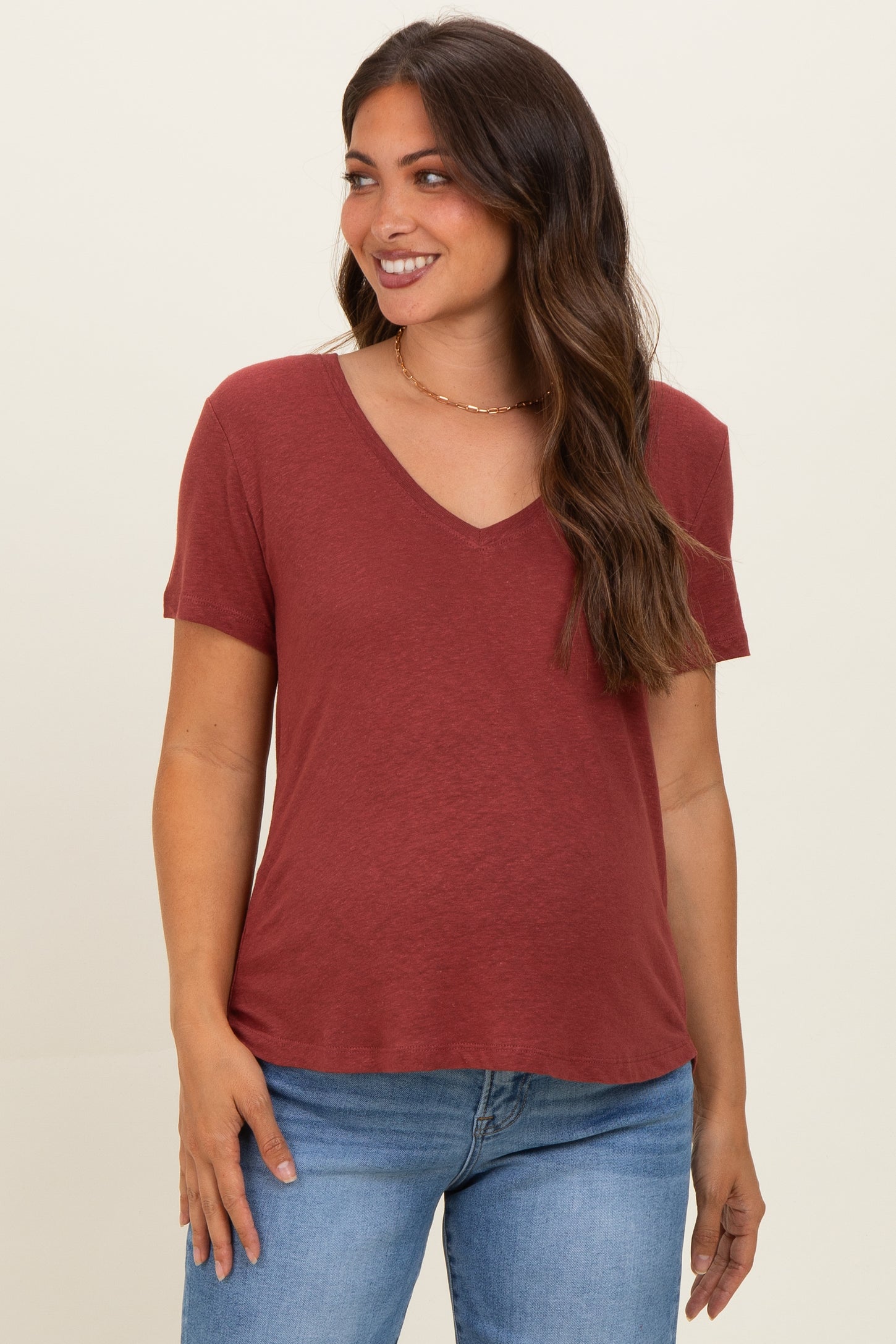woman wearing a rust v-neck maternity t-shirt with short sleeves and relaxed fit
