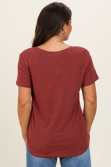 woman wearing a rust-colored short sleeve maternity top seen from the back