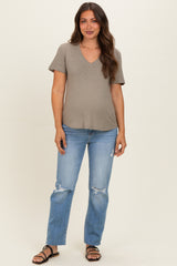 woman wearing a gray v-neck maternity top with short sleeves and distressed blue jeans, showing her baby bump