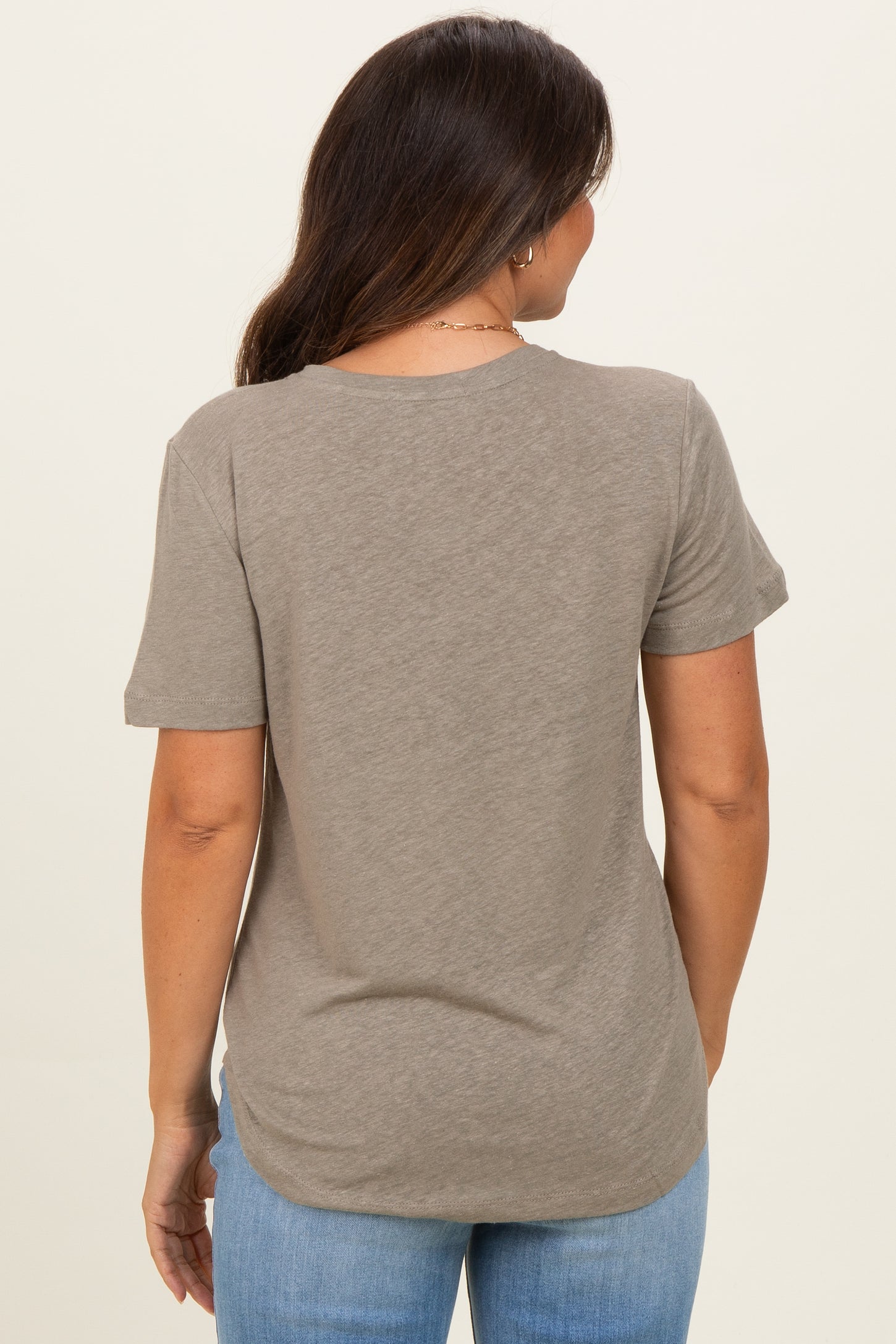 woman wearing a taupe short sleeve maternity top, showing the back view with a relaxed fit
