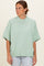 woman wearing a mint green oversized short sleeve sweater with a ribbed neckline and hem