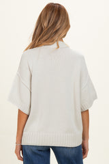 maternity wear in light beige knit sweater with wide sleeves and ribbed hem, shown from the back