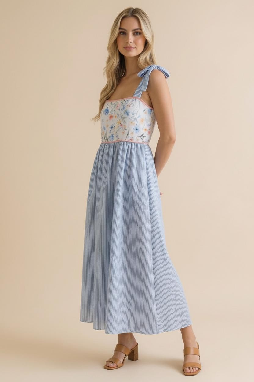 woman wearing a floral and striped maxi dress with tie straps and a fitted bodice