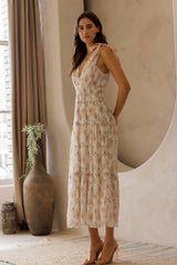 woman wearing a floral print midi dress with tie straps and a tiered skirt