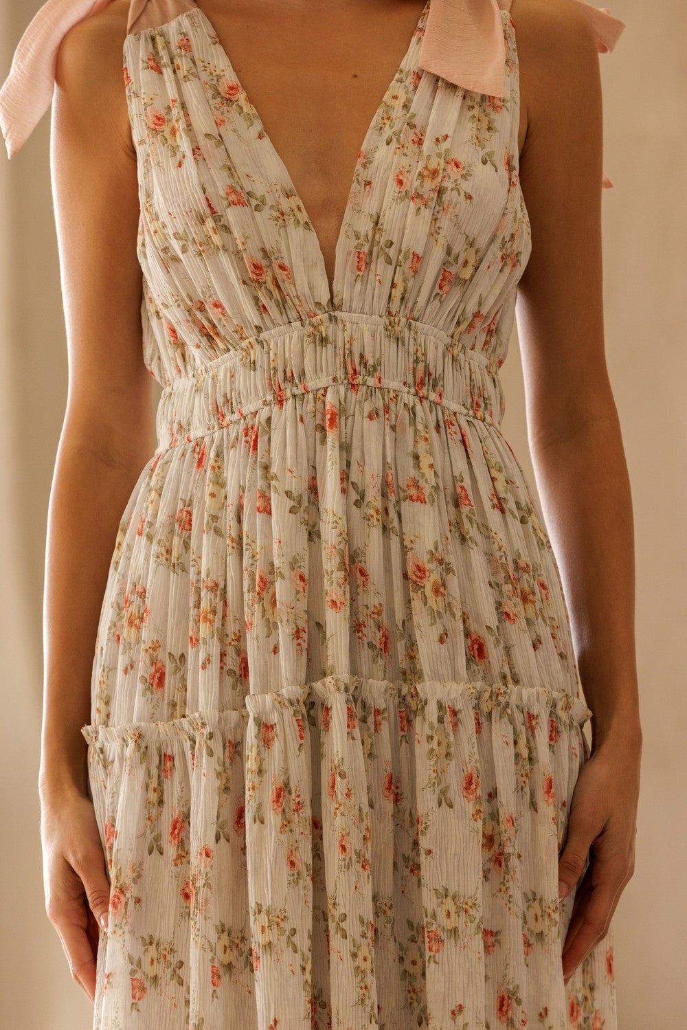 woman wearing a floral patterned midi dress with a deep v-neck and adjustable shoulder straps