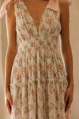 woman wearing a floral patterned midi dress with a deep v-neck and adjustable shoulder straps