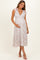 woman wearing a floral maternity maxi dress with bow tie straps and holding her baby bump