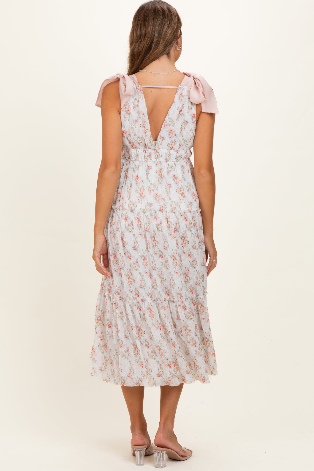 woman wearing a floral print maternity dress with tie sleeves and a V-back, showing a flowing skirt and relaxed fit