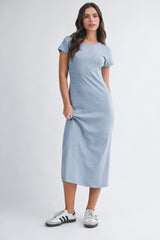 woman wearing a gray short sleeve maxi dress paired with black and white sneakers