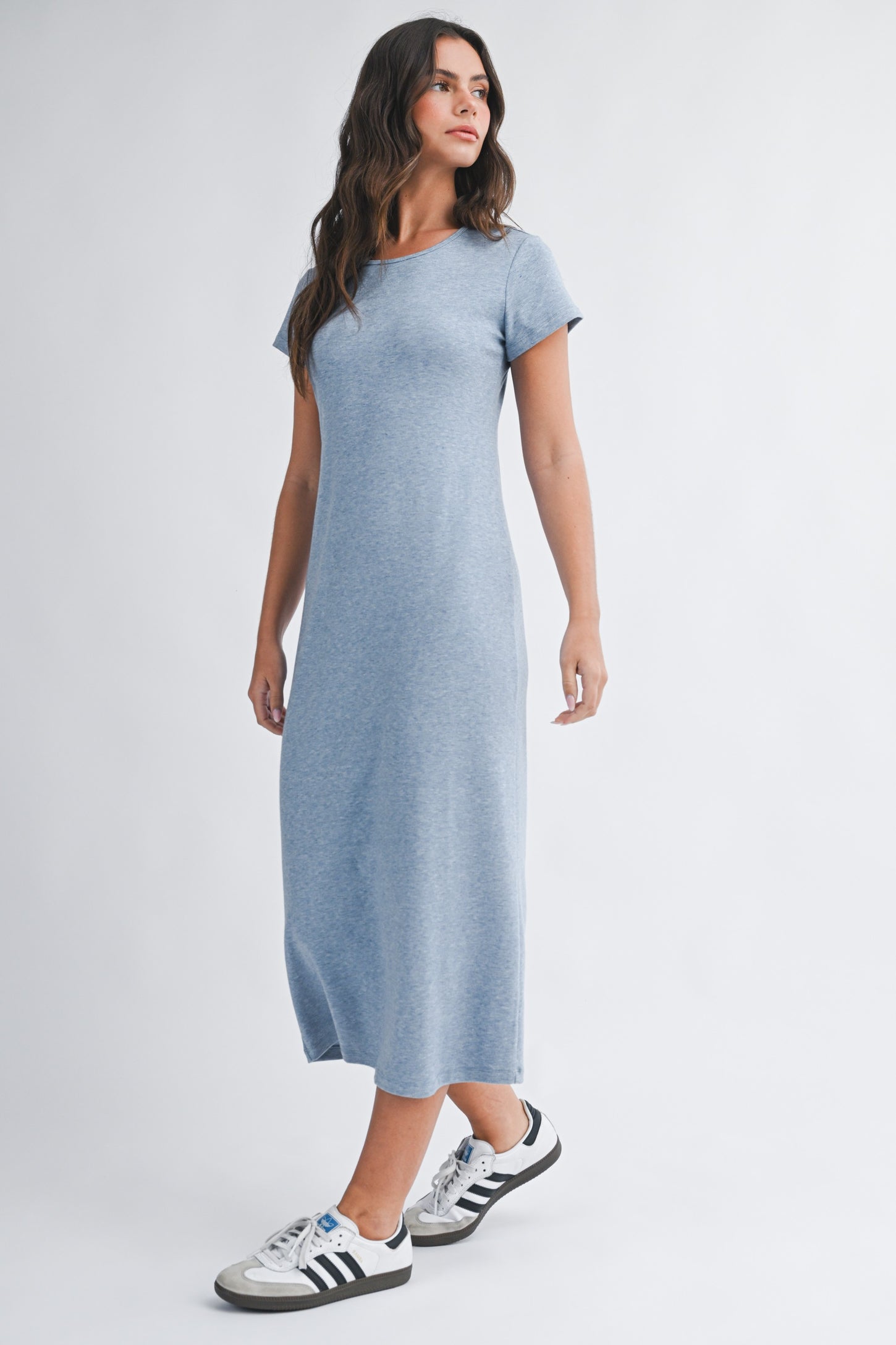 woman wearing a heather blue short sleeve maxi dress with a relaxed fit and standing against a light background