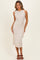 woman wearing a beige sleeveless midi dress with a side knot detail and a fitted silhouette, posing elegantly