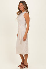 woman wearing a fitted beige midi dress with a tied waist detail and a scoop neckline