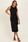 woman wearing a black sleeveless midi dress with a twisted knot detail at the waist