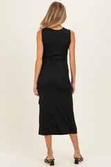 woman wearing a black sleeveless maternity dress with a mid-length hem and a slit at the back