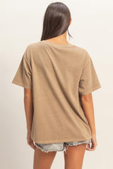 woman wearing a relaxed fit brown oversized t-shirt with short sleeves and back view, paired with denim shorts