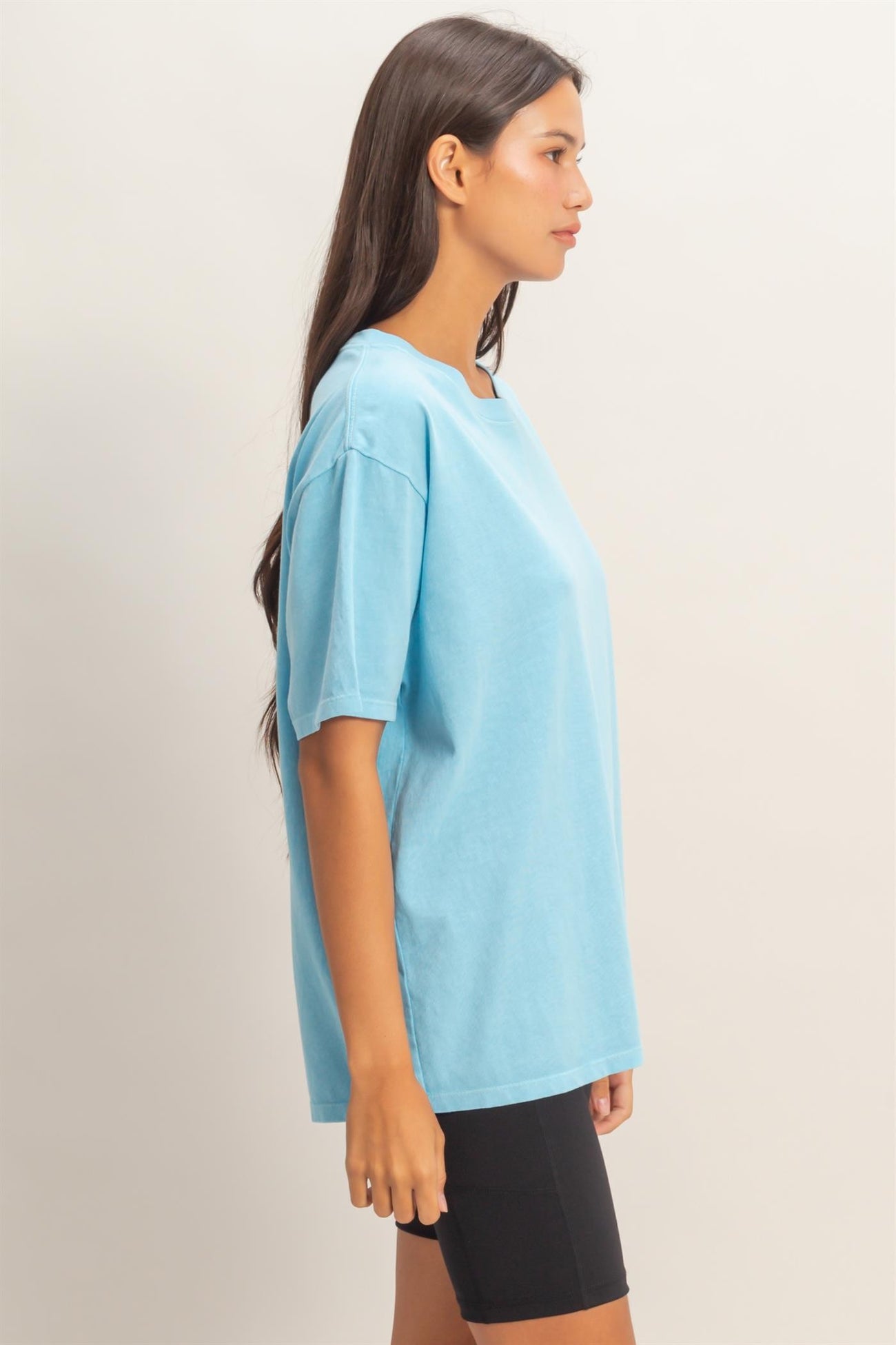 woman wearing a light blue oversized t-shirt paired with black bike shorts