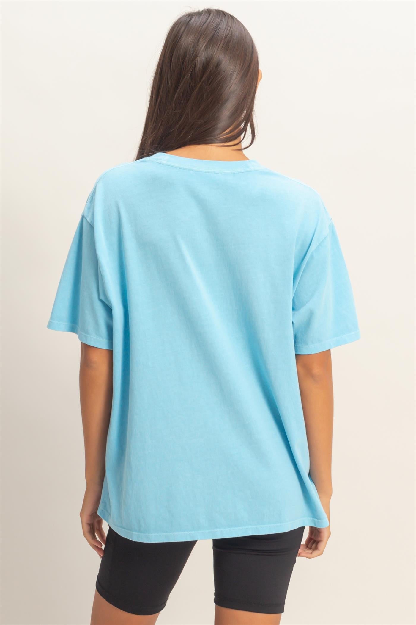 woman wearing a blue oversized t-shirt with short sleeves and back view, paired with black bike shorts