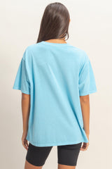 woman wearing a blue oversized t-shirt with short sleeves and back view, paired with black bike shorts