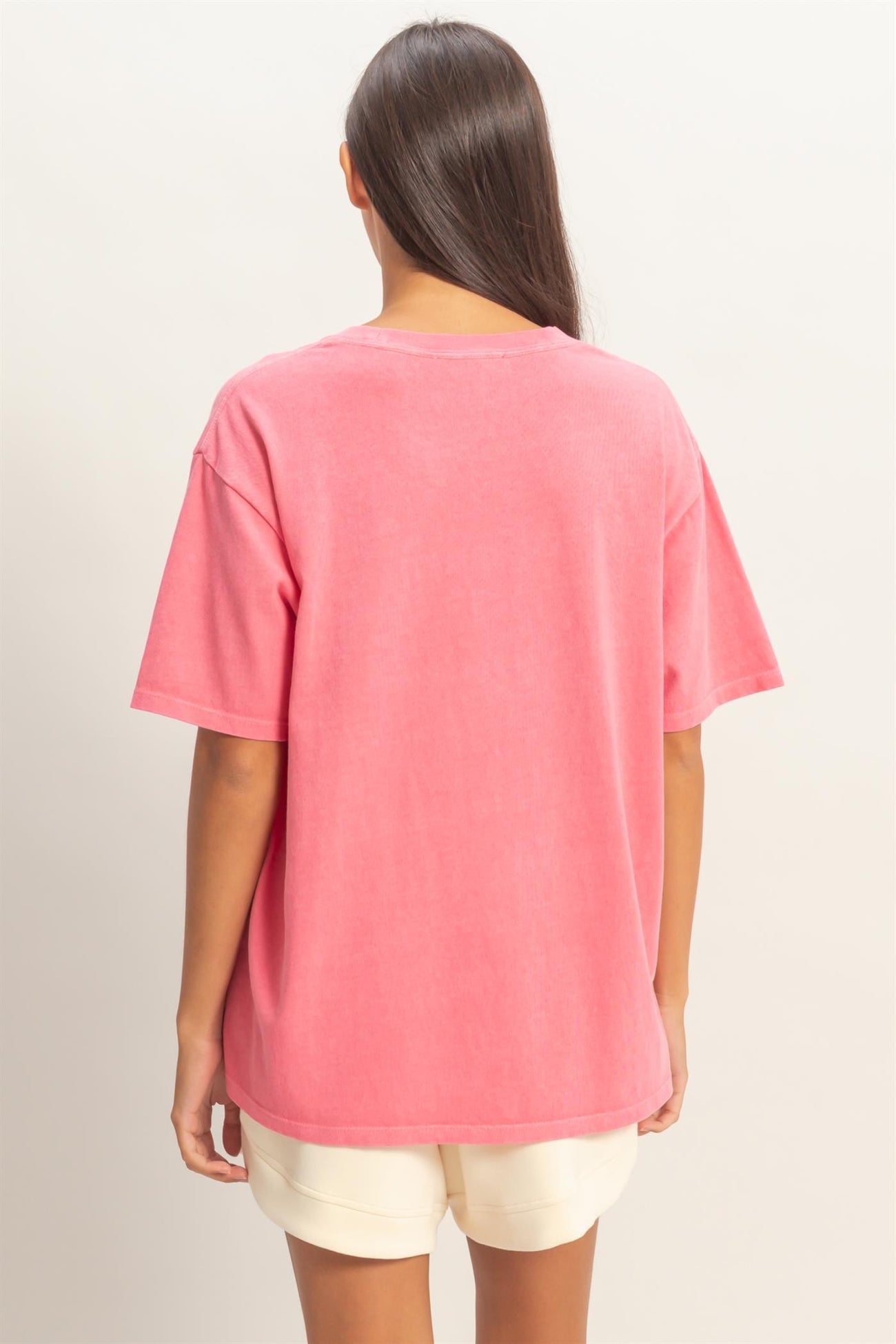 woman wearing a pink oversized t-shirt with short sleeves and a relaxed fit