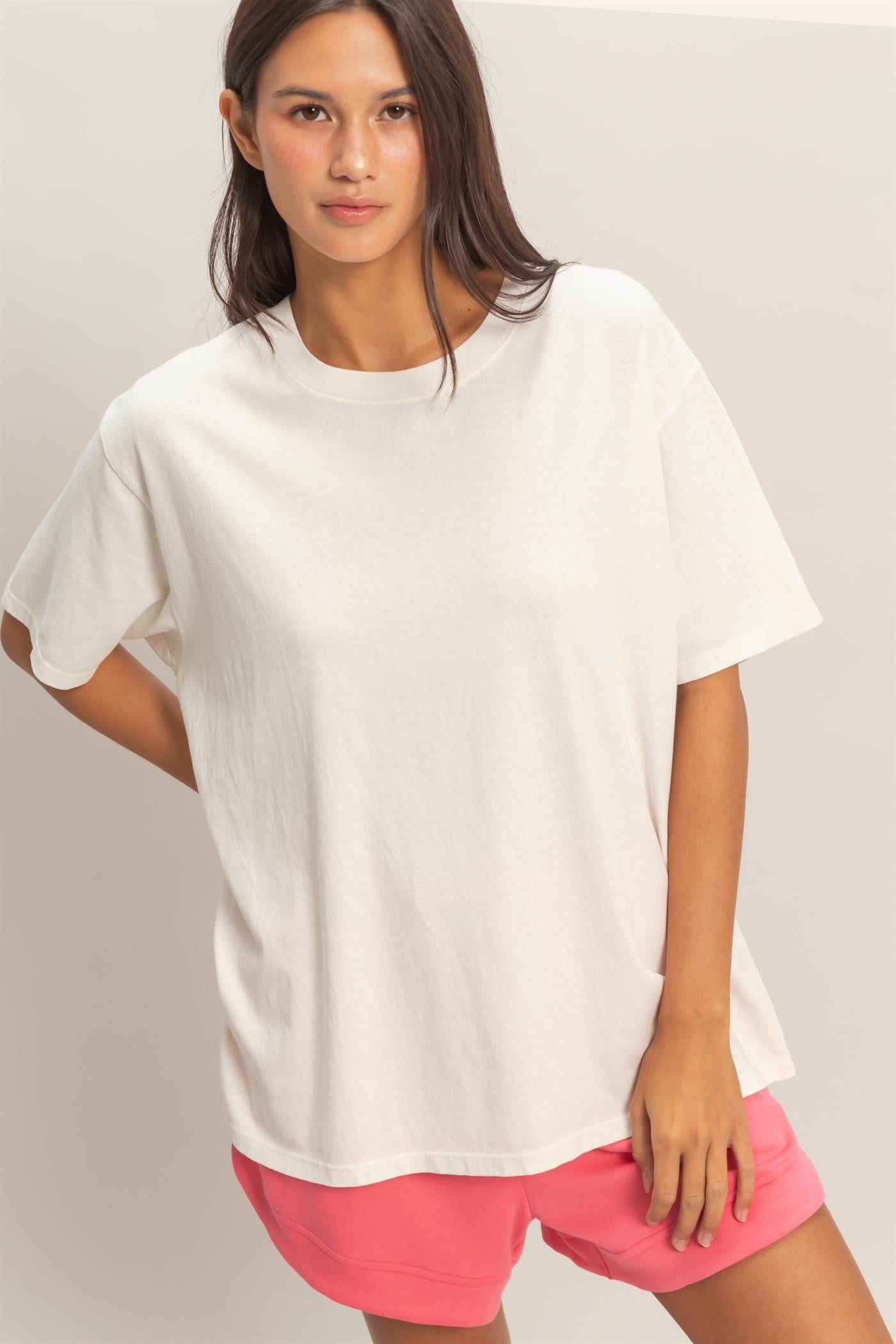 woman wearing a white oversized t-shirt with short sleeves and pink shorts