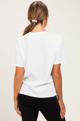 woman wearing a white short sleeve maternity top, viewed from the back, with black leggings