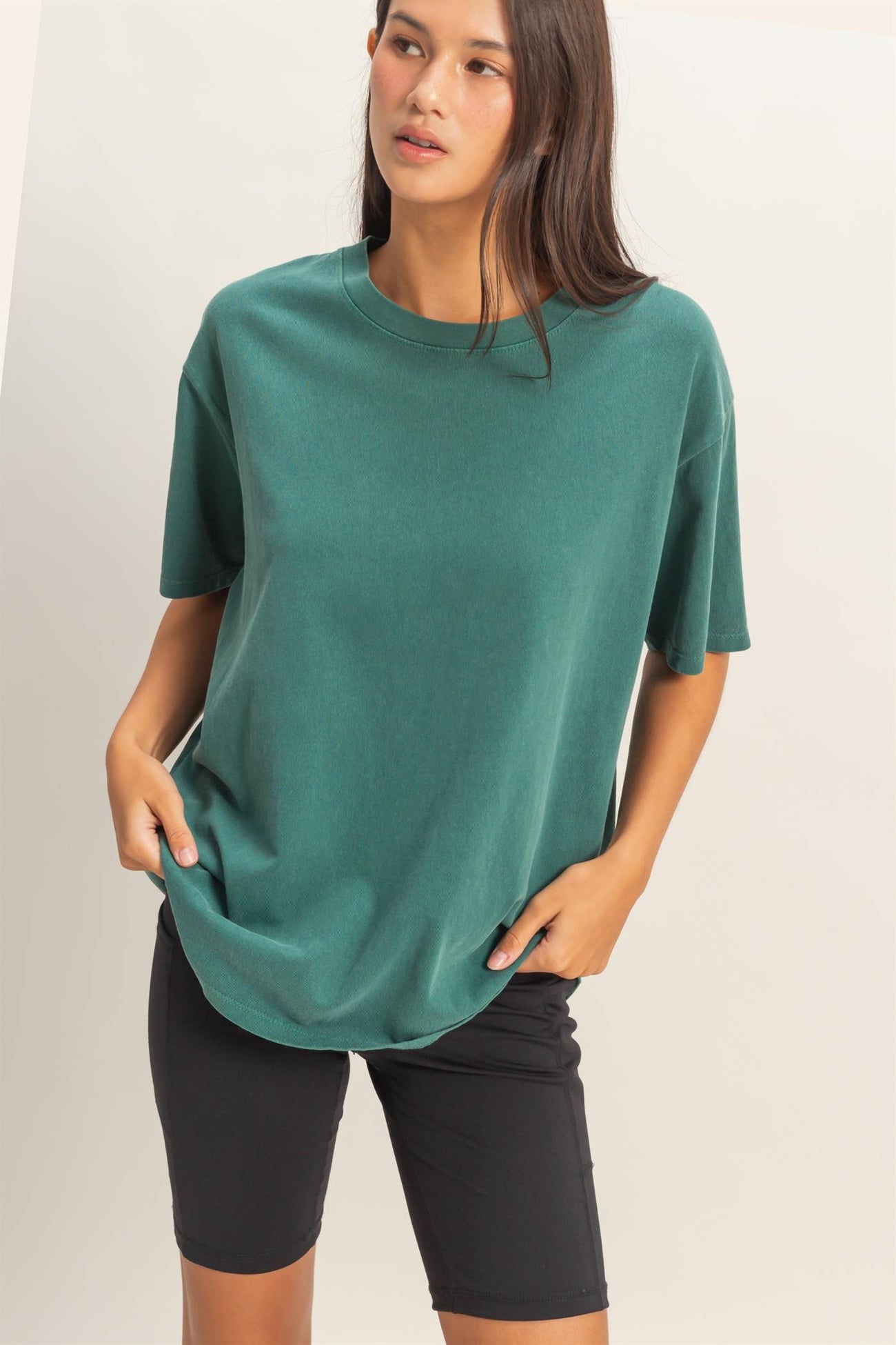 woman wearing a green oversized t-shirt and black bike shorts