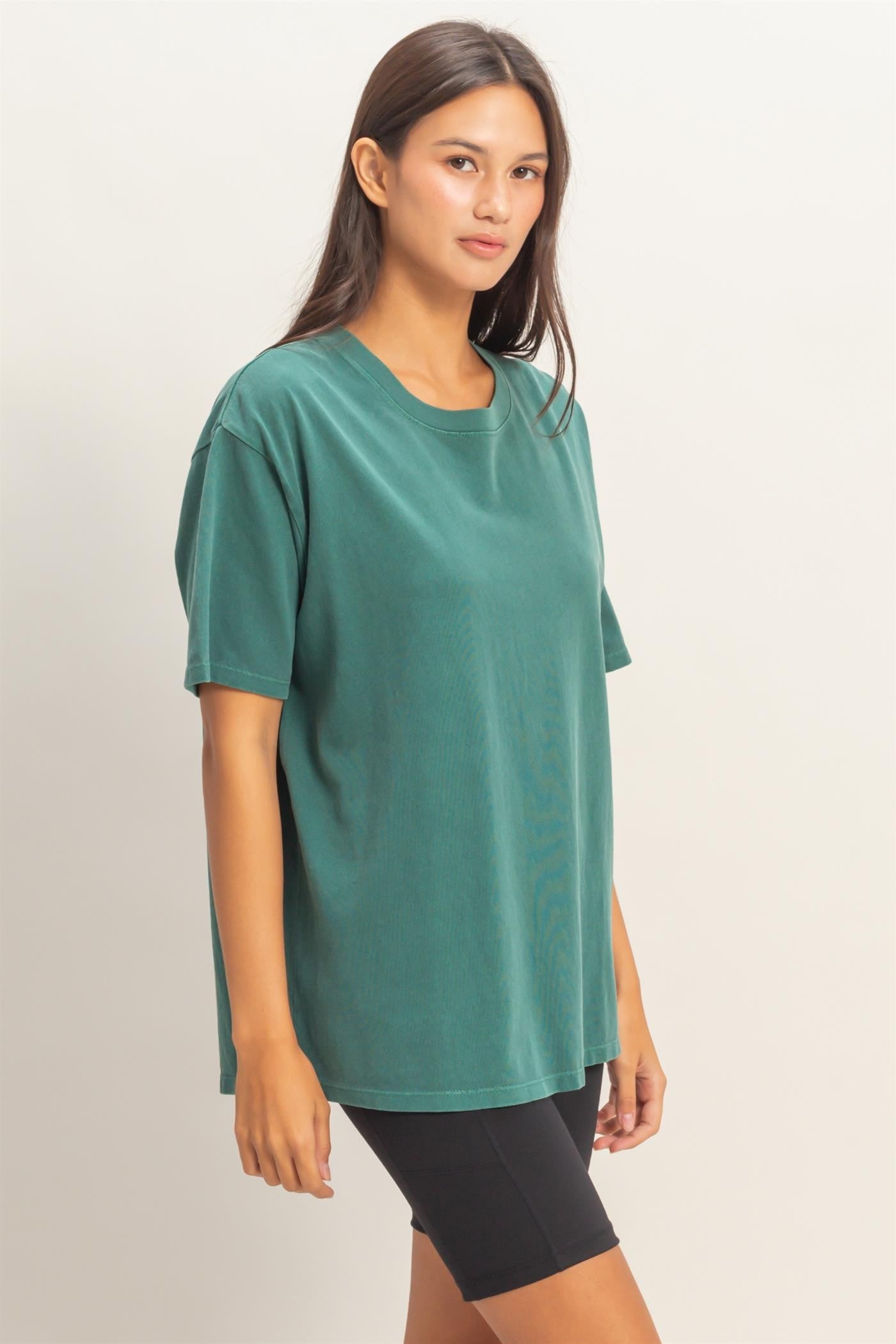 woman wearing an oversized dark green t-shirt paired with black bike shorts
