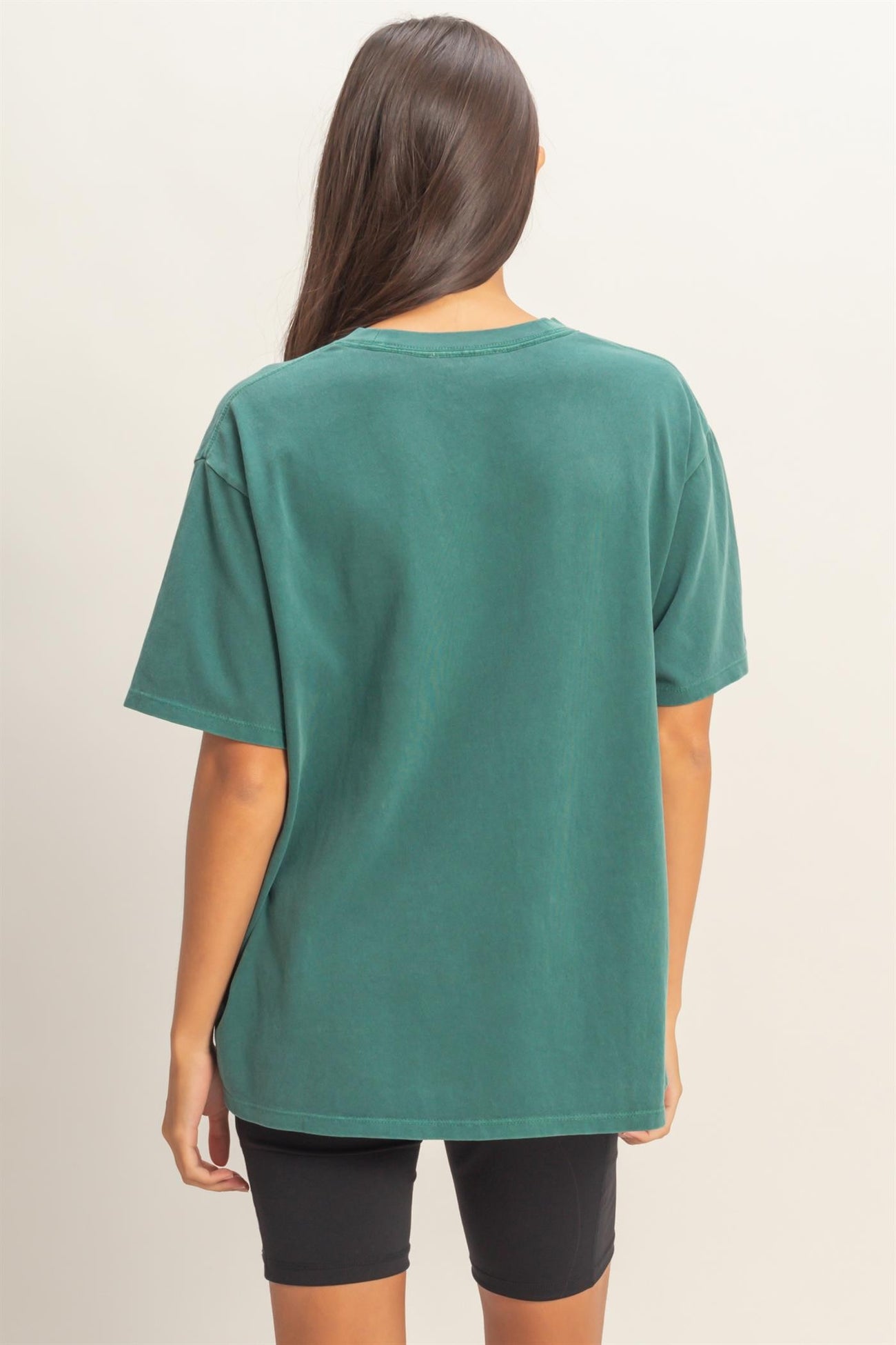 woman wearing a green oversized t-shirt with a relaxed fit and short sleeves, viewed from the back